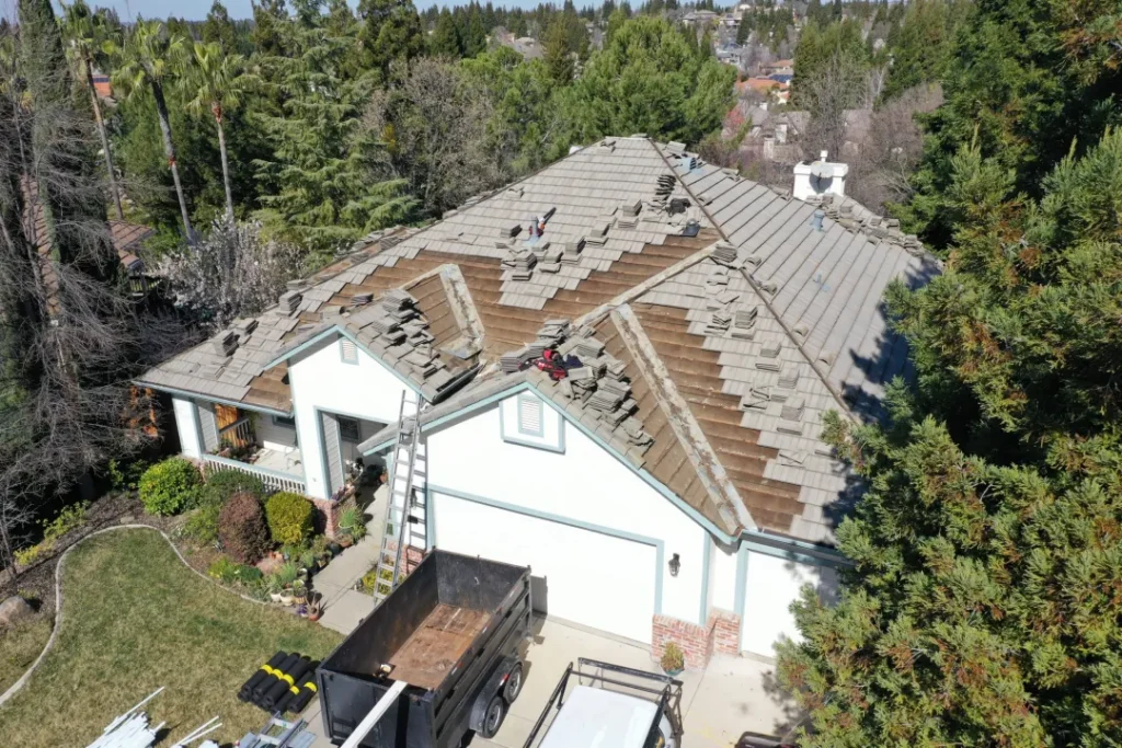 Tile roof replacement in progress with tiles stacked on new underlayment