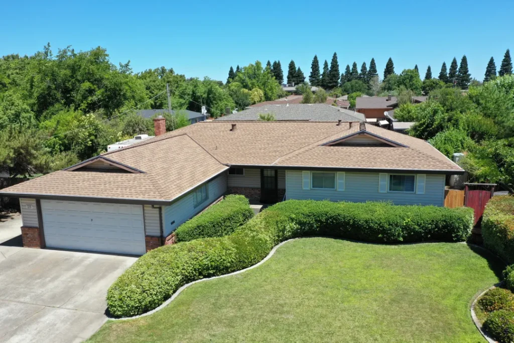 Single-story home with a new tan asphalt shingle roof