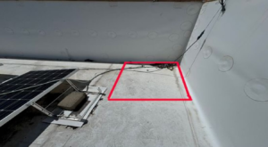 Soft spot outlined in red in the corner of a commercial TPO flat roof in Auburn