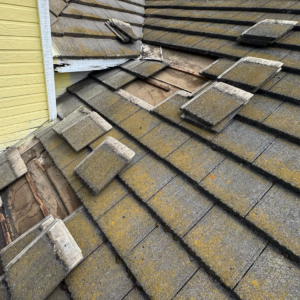 Tile roof by a chimney in Elk Grove with tiles removed, showing damaged underlayment and battens from clogged drainage channels