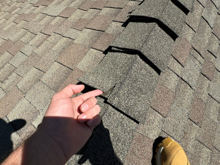 Cracked shingle ridge caps on a Rocklin roof before replacement