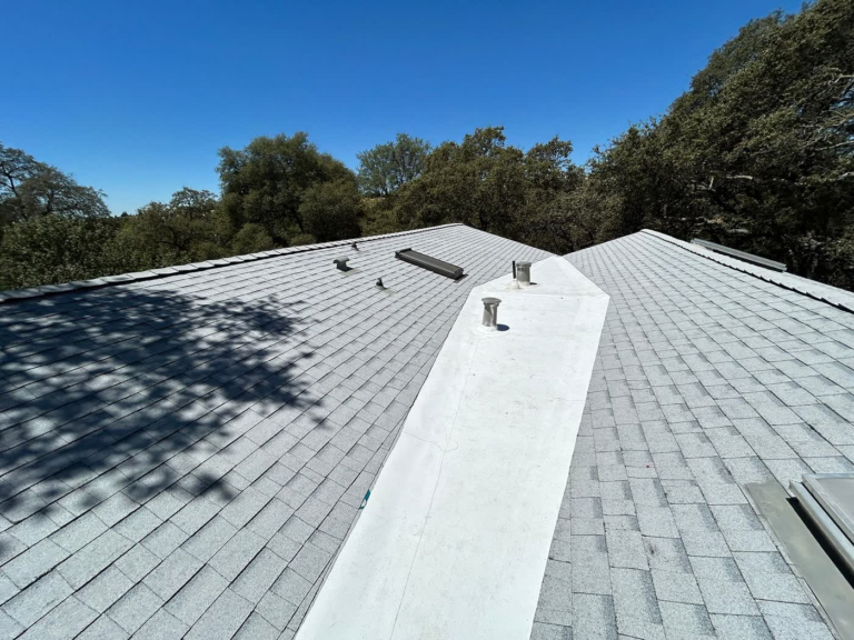 New Owens Corning shingle roof in Rocklin with a white 60 mil TPO cricket where two roofs meet and water drains slowly