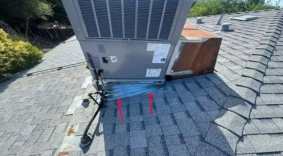 Rooftop HVAC unit set on top of shingles without proper flashing, with arrows marking the leak path