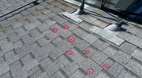 Nails pushing up through a second layer of shingles, circled in red