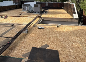 New plywood decking installed after the tear-off on a commercial flat roof replacement in Sacramento