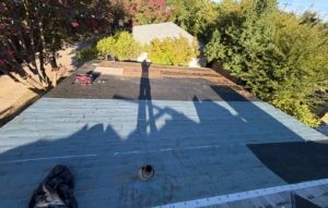 Low-slope patio roof on a Sacramento home after tear-off, before the dry rot was replaced