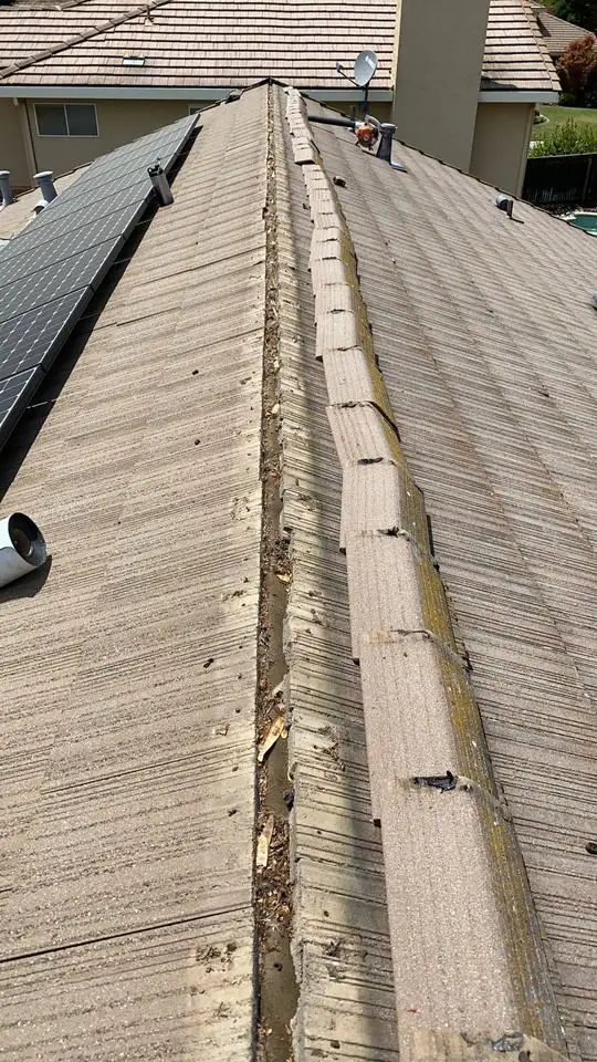 Tile roof ridge with caps removed before flash band seal is installed