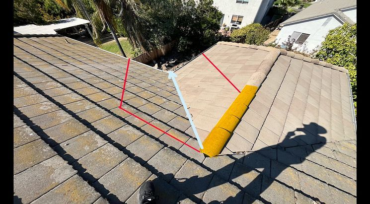 Tile roof valley and ridge marked up during an inspection to show the repair areas
