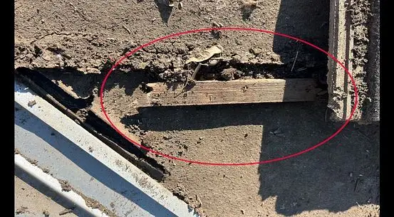Worn underlayment and wood exposed in a tile roof valley, circled in red